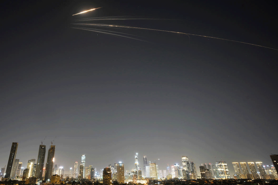 Missiles launched from Iran streak across the sky over central Israel, Wednesday, March 18, 2026.