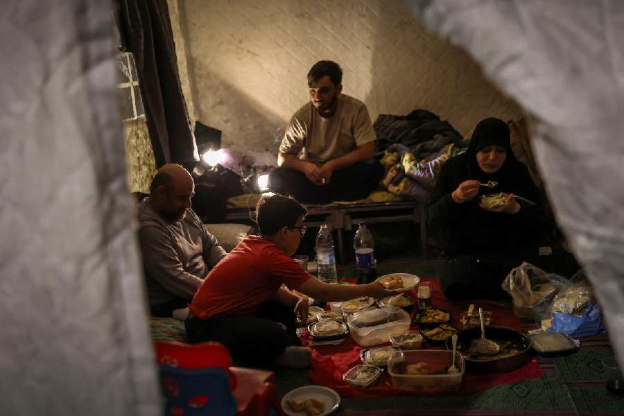 Family members break their fast at iftar during Ramadan as they shelter at Camille Chamoun Stadium, Beirut