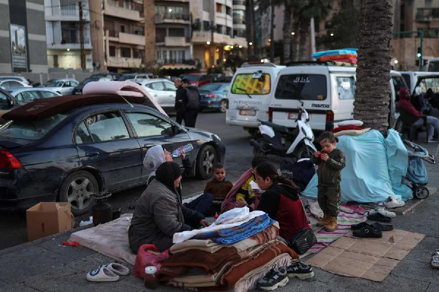 A family breaks their fast at iftar during Ramadan, as they sit on the street in Beirut where they have been living following an escalation between Hezbollah and Israel 
