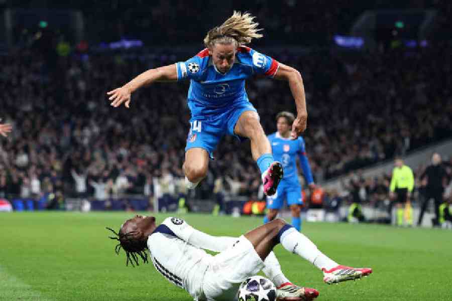 Atletico Madrid’s Marcos Llorente jumps over Tottenham Hotspur’s Mathys Tel during Wednesday’s Champions League round-of-16 second-leg match at Tottenham Hotspur Stadium in London. (Getty Images)