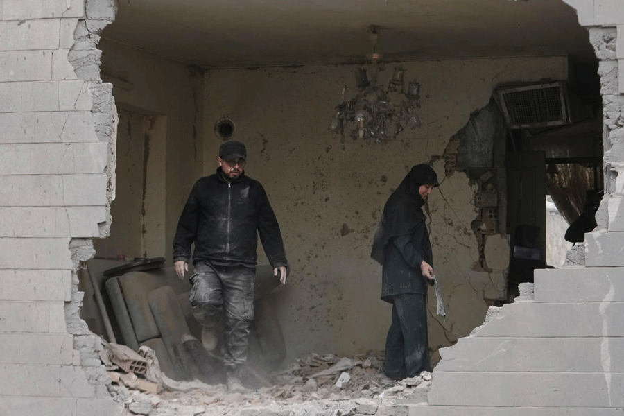 People clean debris from their apartment in Tehran, Iran