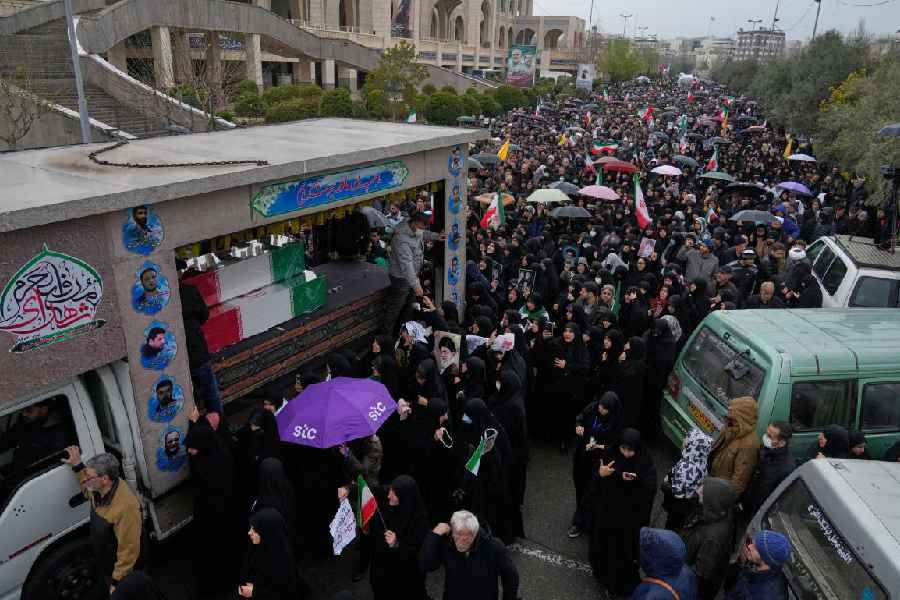 Iranians follow a truck carrying the flag draped coffins of Iran's intelligence minister Esmail Khatib and, according to Iranian officials, his wife and daughter, during a funeral procession in Tehran, Iran, Friday, March 20, 2026.