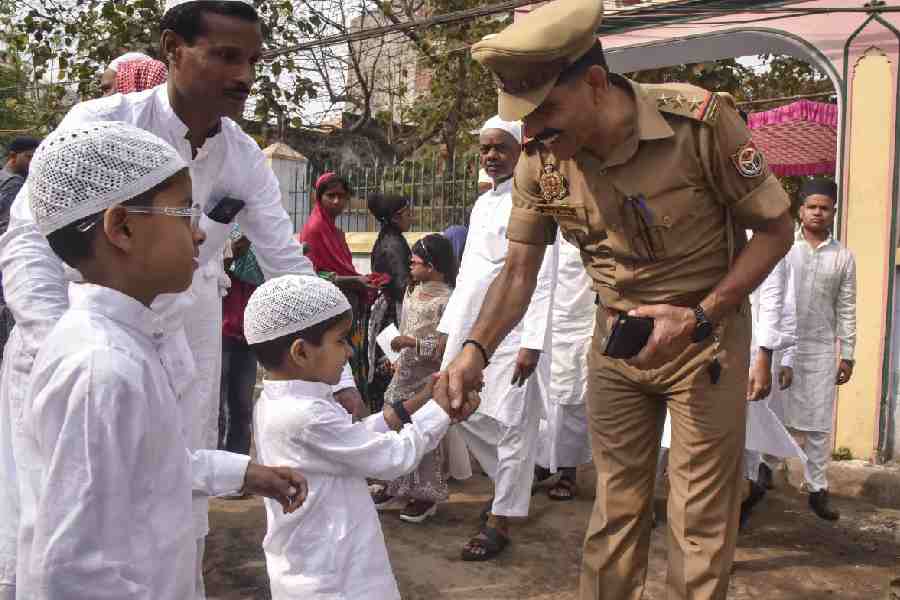 A police officer greets Muslim children on Eid al-Fitr, at an Eidgah in Varanasi, Uttar Pradesh, Saturday, March 21, 2026.