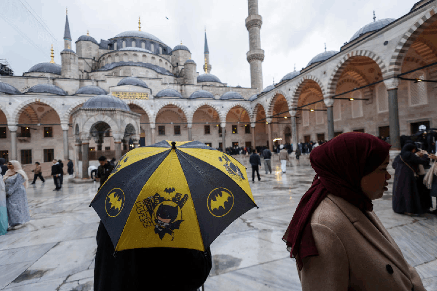 People stroll at the courtyard of Sultanahmet Mosque, known as the Blue Mosque, after Eid al-Fitr prayers marking the end of the fasting month of Ramadan, in Istanbul, Turkey, March 20, 2026. 