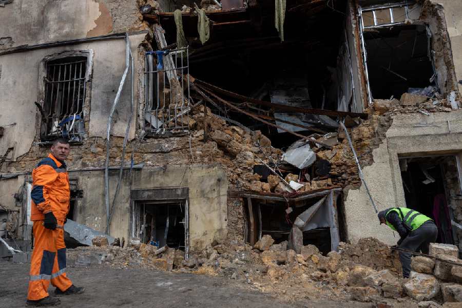 Municipal workers clear the rubble of residential building damaged after a Russian drone strike in Odesa, Ukraine, on Thursday, March 19, 2026.