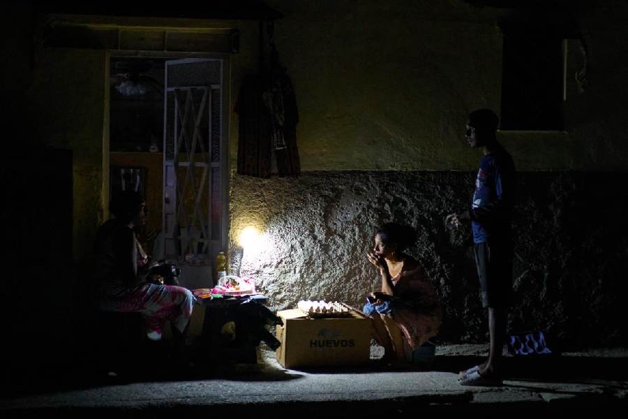 Street vendors talk amongst themselves during a blackout in Havana, Monday, March 16, 2026.
