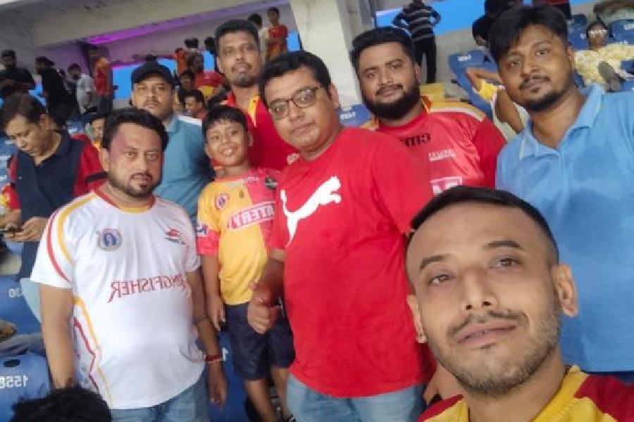 Arup Banerjee takes a picture with friends after watching a football match at the Salt Lake Stadium.