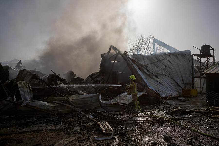 A firefighter works to extinguish a fire at the site of a direct hit from an Iranian missile in central Israel, Wednesday, March 18, 2026.