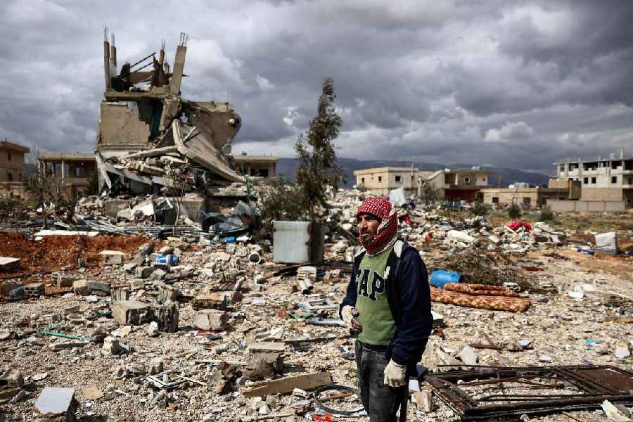 A man stands next to debris caused by an Israeli strike, following an escalation between Hezbollah and Israel, amid the U.S.-Israeli conflict with Iran, during a media tour in Chaat, Lebanon