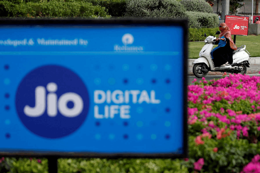 A woman rides her scooter past advertisements of Reliance Industries' Jio telecoms unit, in Ahmedabad, India, July 5, 2018.
