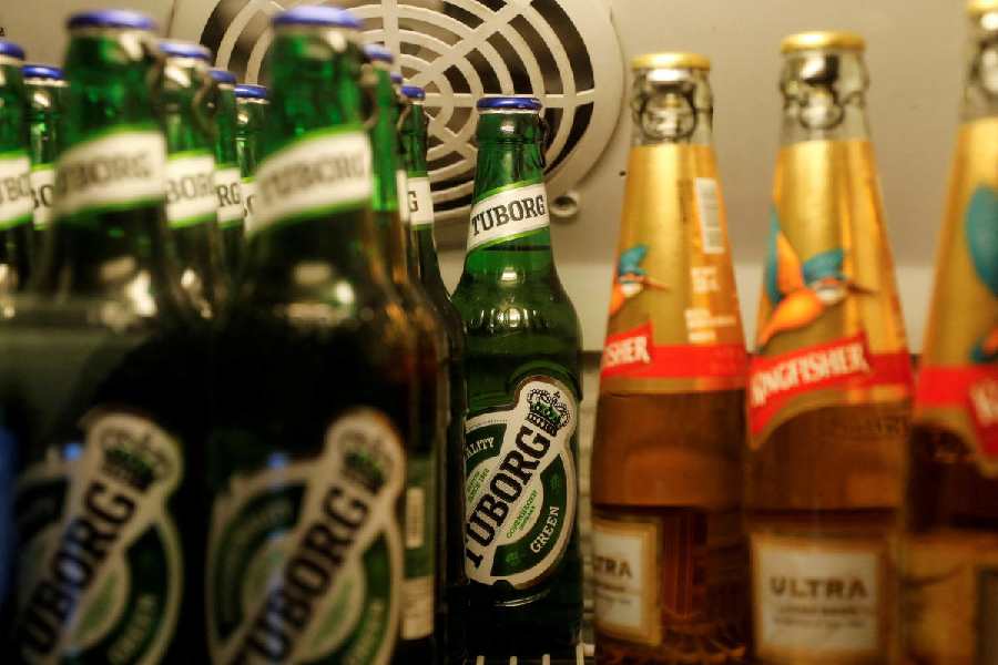 Bottles of Kingfisher and Tuborg beer are displayed in a fridge at a pub in Mumbai, India