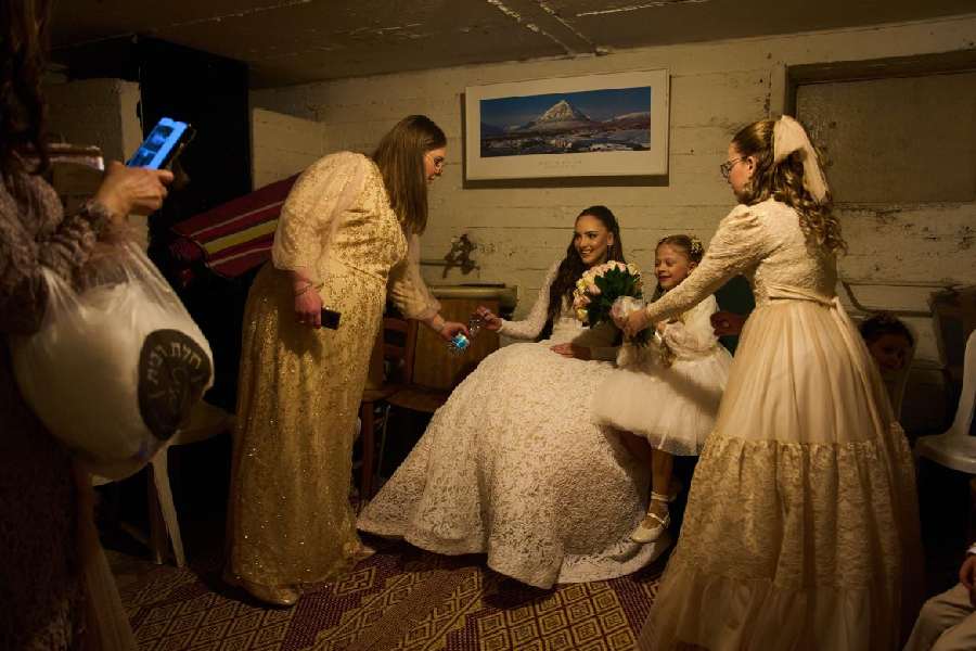 A bride and her family sit in a bomb shelter after an alert warning of missiles fired from Iran toward central Israel interrupted their wedding photo shoot in a nearby park in Ramat Gan, Israel, Thursday, March 19, 2026.