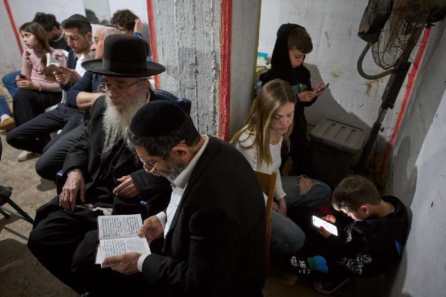 People take cover in an underground bomb shelter as air raid sirens warn of incoming Iranian missile strike, in Ramat Gan, Israel, Wednesday, March 11, 2026.