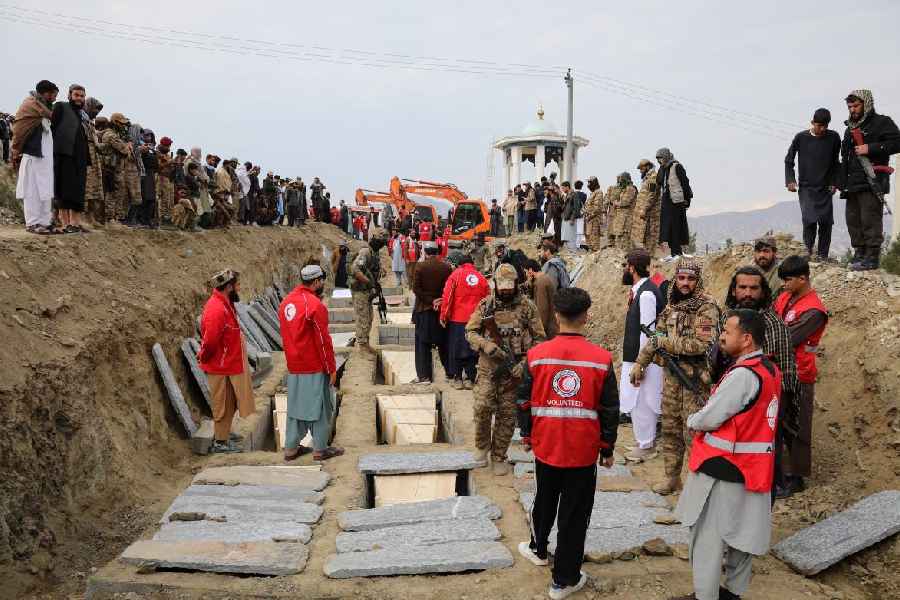 Coffins are placed in a grave during a second mass funeral for victims of an airstrike in Afghanistan