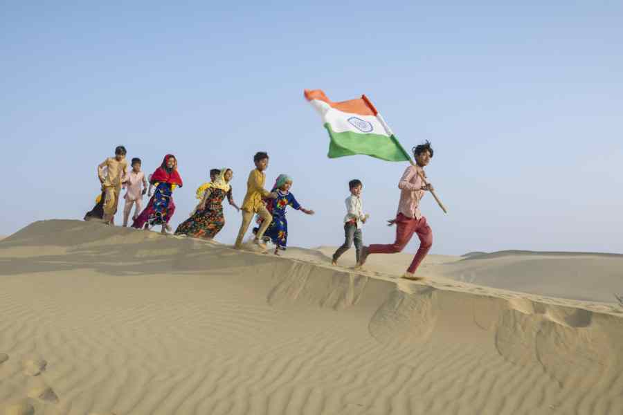 Group of happy Indian children running with Indian national flag, India