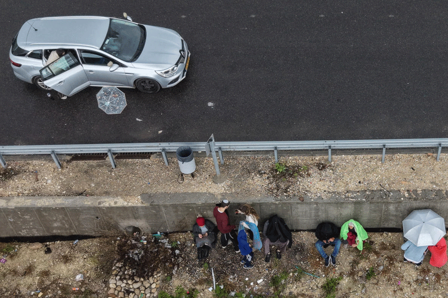 A drone photo of people taking shelter at the side of a road as sirens sound following the launch of a barrage of Iranian missiles towards Israel, amid the U.S.-Israel conflict with Iran, near Arad, southern Israel March 26, 2026.
