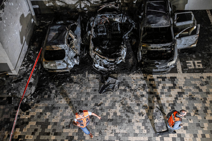 Israeli rescue personnel inspect the impact site following Iranian missile barrages