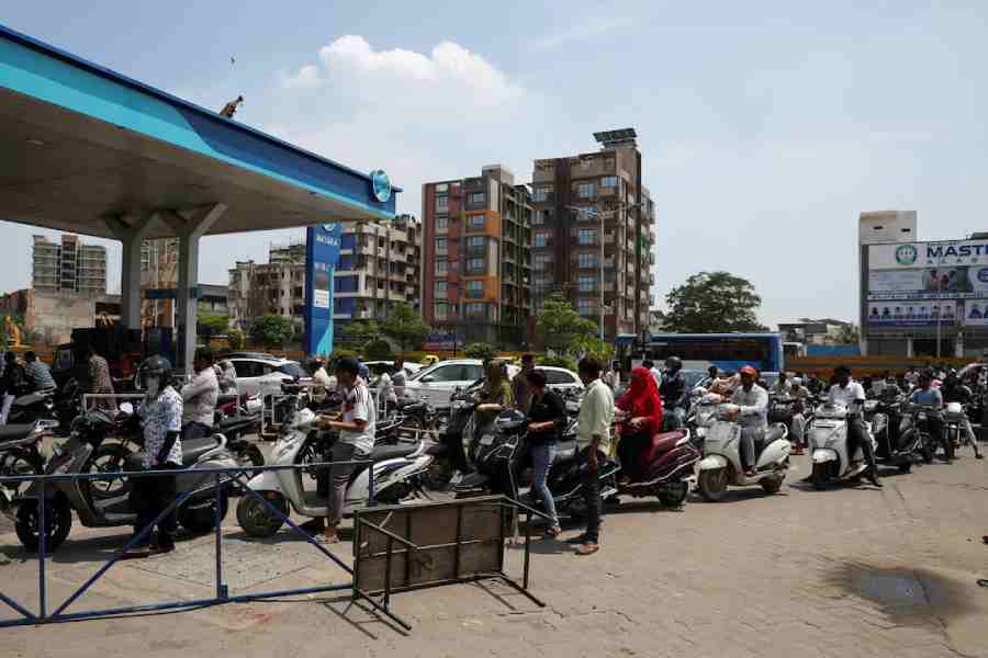 People queue to fill petrol in their two-wheelers with concerns over potential supply disruptions, but authorities say there are no shortages, amid the ongoing US-Israeli conflict with Iran, in Ahmedabad, India, March 24, 2026.