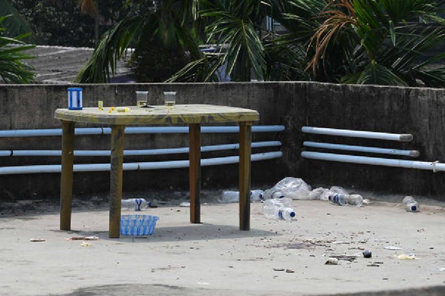 Plastic glasses, bottles, shards of glass and other items strewn across the terrace of the building near Garia on Thursday