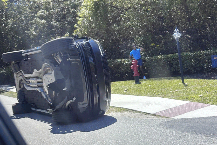 Golfer Tiger Woods stands by his overturned vehicle in Jupiter Island, Fla., on Friday, March 27, 2026.