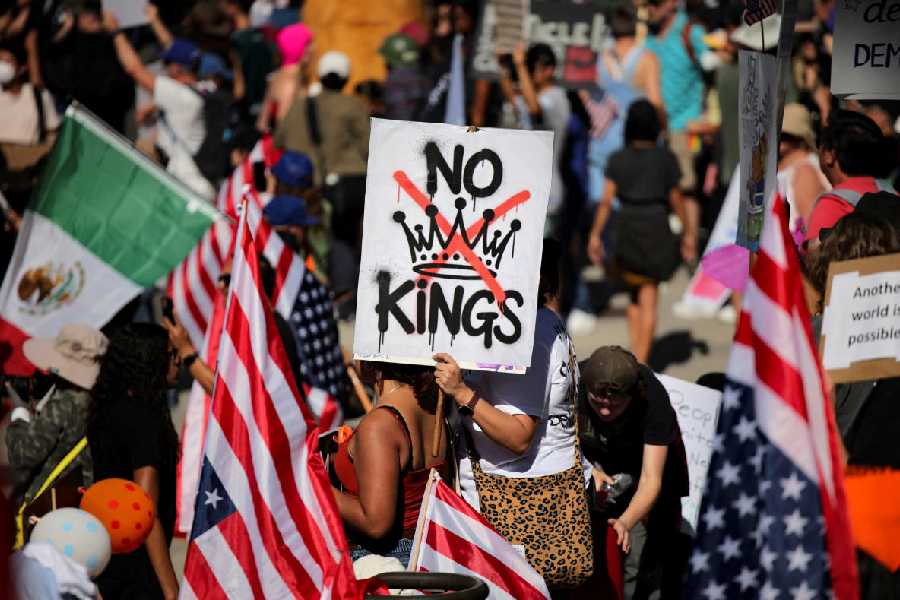 A protester holds a sign  during a "No Kings" protest against US President Donald Trump's policies, outside City Hall in Los Angeles