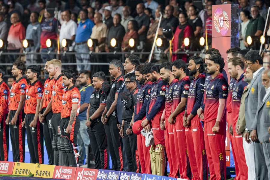 Members of Royal Challengers Bengaluru and Sunrisers Hyderabad, Karnataka State Cricket Association (KSCA) President Venkatesh Prasad and others observe a moment of silence as a tribute to victims of 2025 stampede, before an Indian Premier League (IPL) 2026 T20 cricket match between Royal Challengers Bengaluru and Sunrisers Hyderabad, at the M Chinnaswamy Stadium, in Bengaluru, Karnataka, Saturday, March 28, 2026.