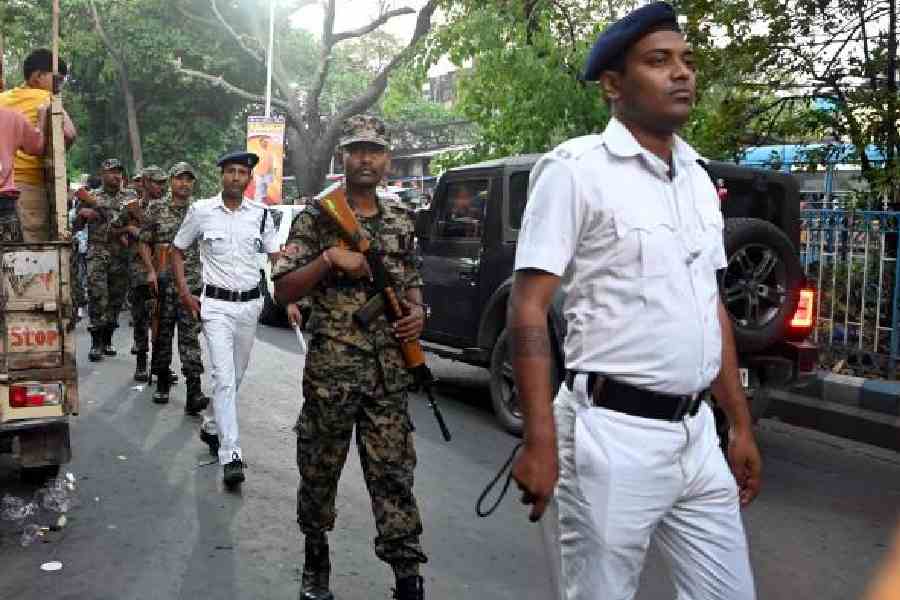 Central forces personnel and a police officer on a route march in Entally on Thursday. (Sanat Kr Sinha)