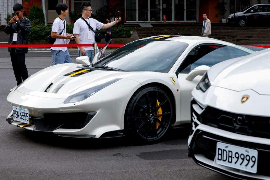 People take photos of a Lamborghini Urus and a Ferrari 488 Pista as Taiwan auctions off luxury cars