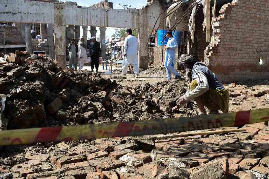 A man clears the rubble of his damaged house, collapsed after heavy rains
