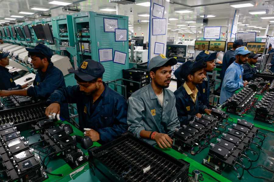 Workers stand along the assembly line at a Dixon Technologies facility in Noida, India, May 20, 2025.