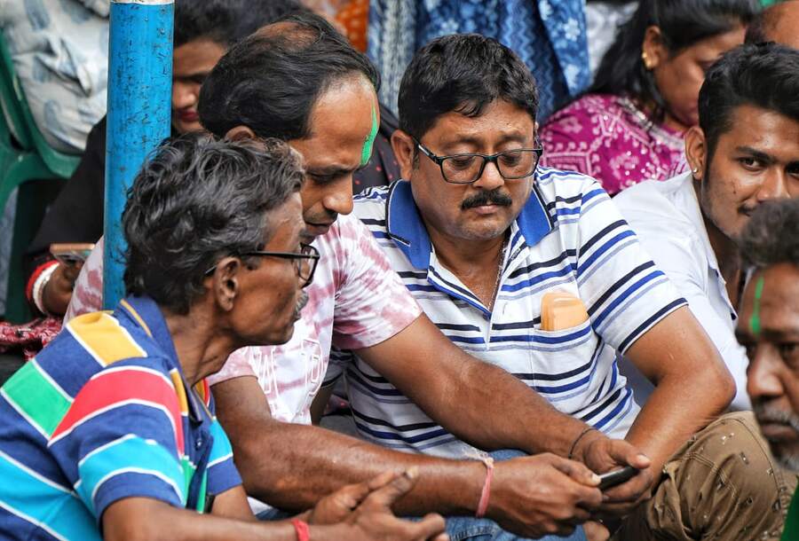 Small groups gathering near counting centres, watching closely as trends begin to emerge after 11am