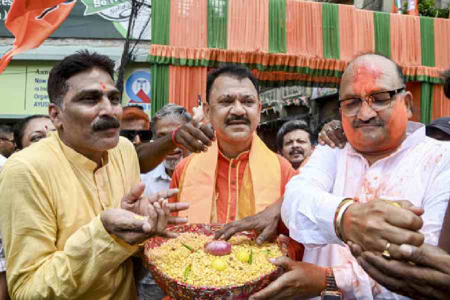 BJP workers serve jhal muri to celebrate the election victory at the state party headquarters in Calcutta on Monday. (PTI picture)