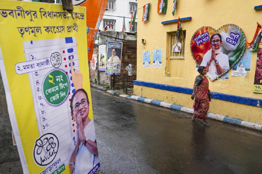 A woman walks past banners of the outgoing West Bengal Chief Minister Mamata Banerjee as security has been scaled down near the latter's residence following her defeat in the state Assembly elections, at Kalighat area, in Kolkata, Wednesday, May 6, 2026. 