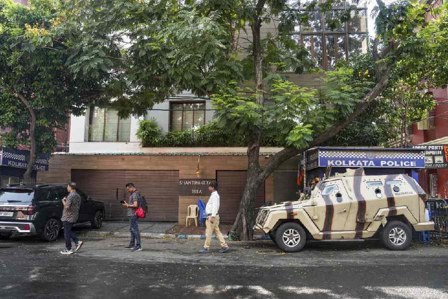 People walk past the entrance of TMC leader Abhishek Banerjee's residence as security has been scaled down outside the residence 'Shantiniketan' following the party's defeat in the state Assembly elections, in Kolkata, Wednesday, May 6, 2026.