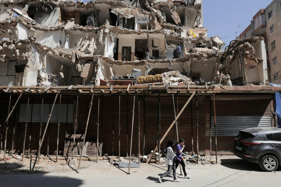 People walk in front of a damaged building in the southern suburbs of Beirut, Lebanon, May 8, 2026.