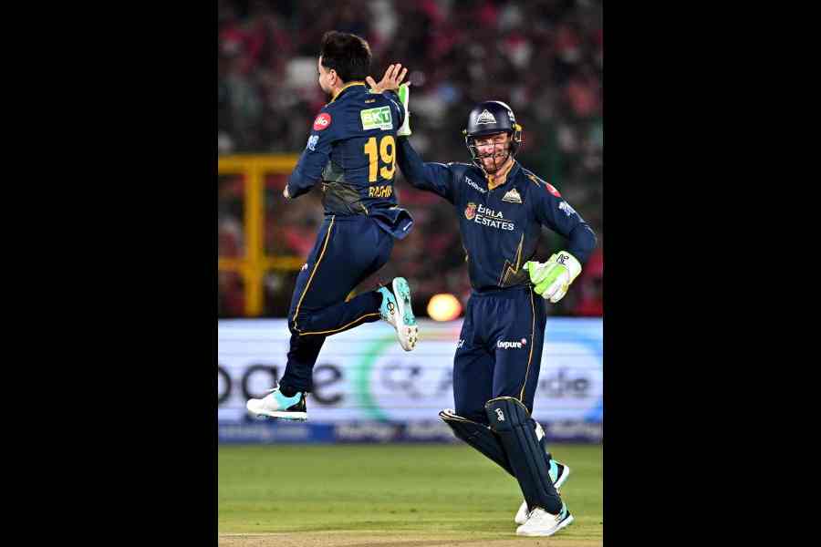 Man of the Match Rashid Khan of Gujarat Titans (left) celebrates with Jos Buttler after dismissing Rajasthan Royals’ Dhruv Jurel in Jaipur on Saturday.