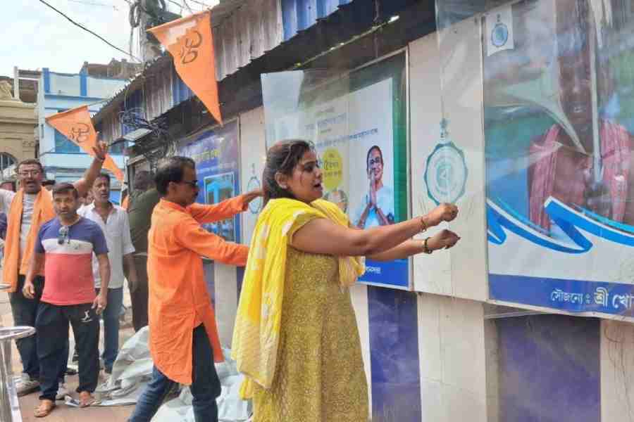 BJP workers tear off banners depicting the social welfare schemes of the previous government near Curzon Gate in Burdwan last week.
