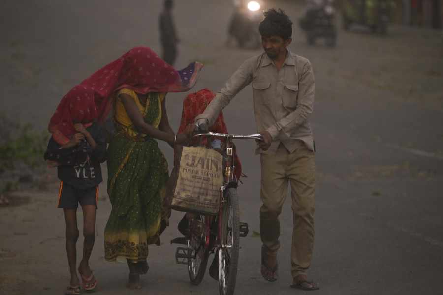 Commuters make their way through a dust storm