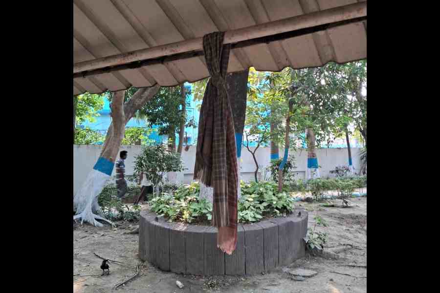 A gamchha hung out to dry over a covered seat built for senior citizens in the park