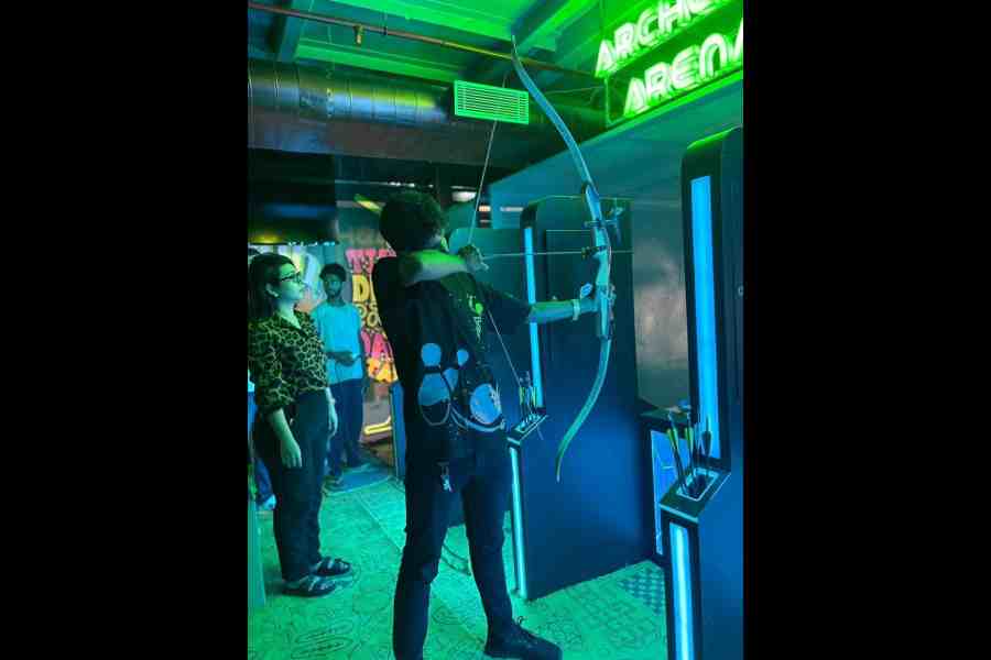 An instructor demonstrates archery for visitors