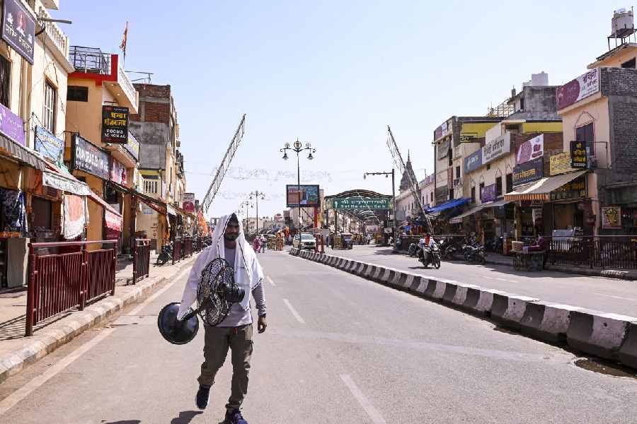 A man carries a fan while walking on a road