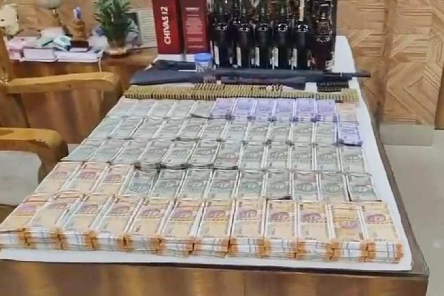 Wads of cash, arms and liquor bottles recovered from Trinamool leader and North 24-Parganas zilla parishad member Ajit Saha and his brother Sujit Saha. 