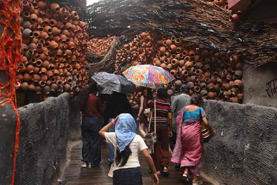 Pandal hoppers amid rain at the Nalin Sarkar Street puja on Saturday afternoon.