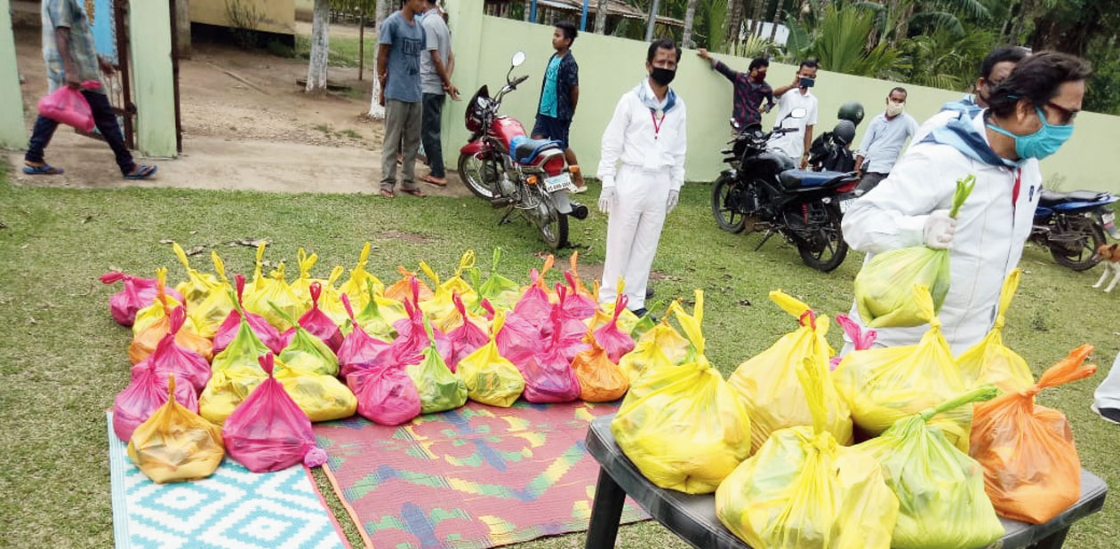 Members of Sri Sathya Sai Seva Organisation distribute relief packets. 
