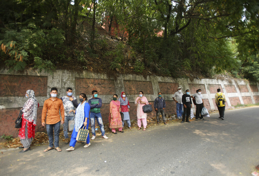 Health workers wait for transport outside a hospital in Jammu, Tuesday, June 23, 2020
