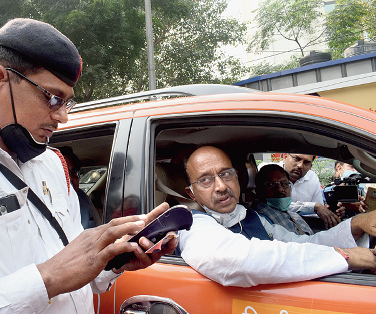 A traffic policeman hands a challan to BJP leader Vijay Goel for violating the odd-even rule in New Delhi on Monday