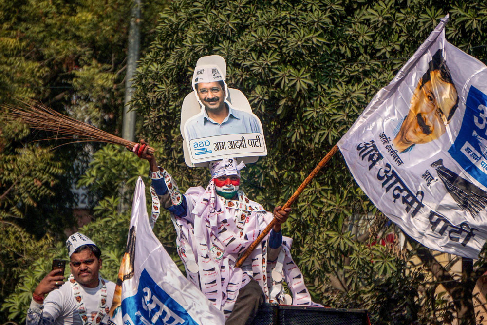 AAP volunteers during an election campaign roadshow in support of the party candidate and Transport Minister Kailash Gahlot (unseen) in Najafgarh constituency, ahead of the State Assembly elections