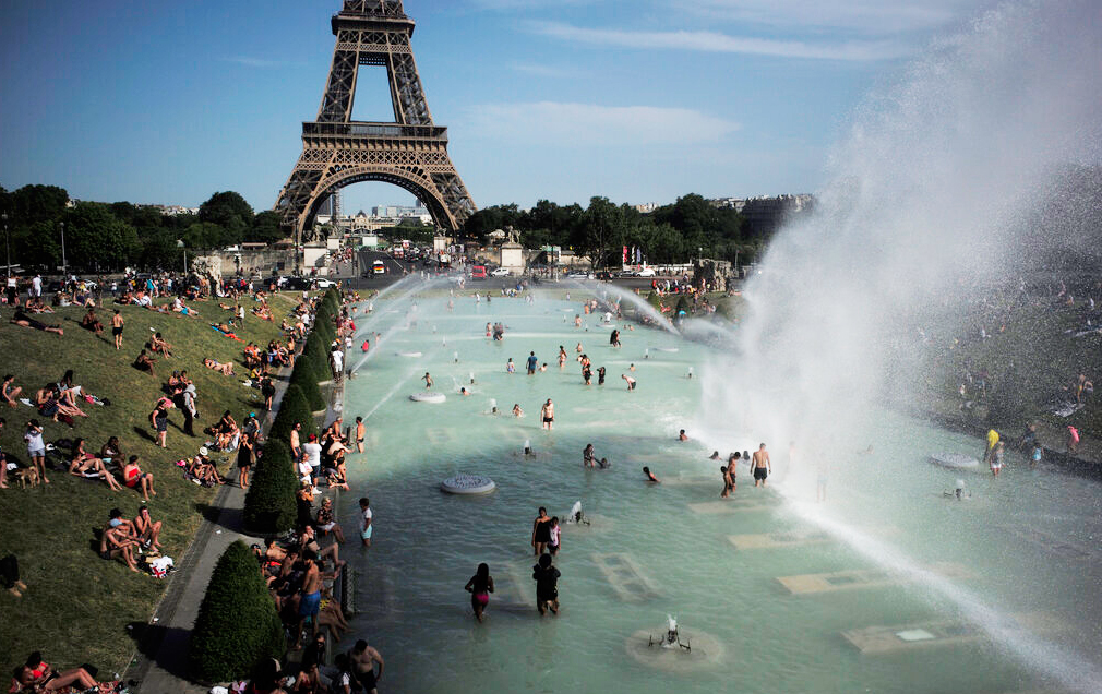 People cool off in the fountains of the Trocadero gardens, in front of the Eiffel Tower, in Paris, Friday, June 28, 2019.