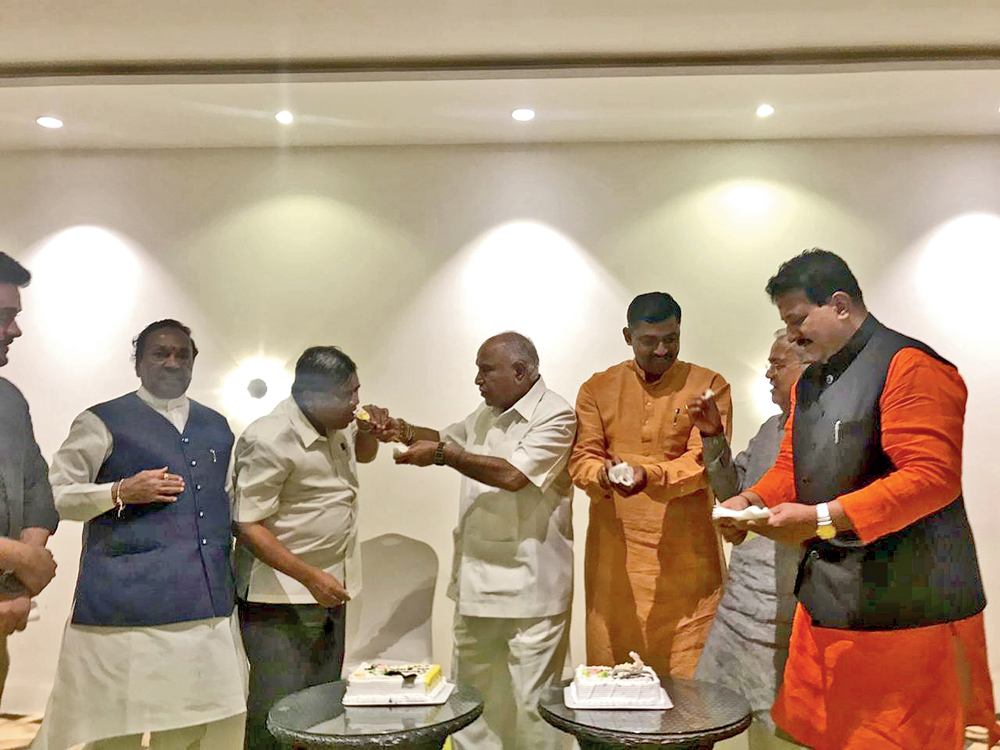 BJP state president BS Yeddyurappa celebrates with party colleagues by cutting a cake in Bangalore after HD Kumaraswamy lost the vote of confidence in the Assembly on Tuesday
