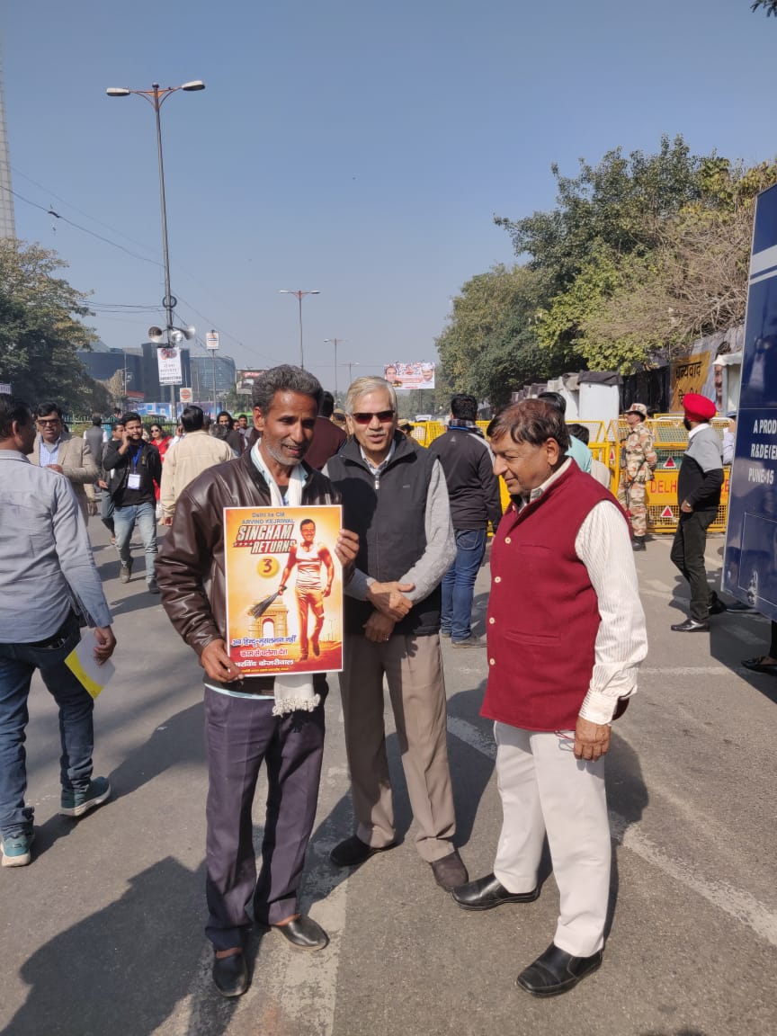 A.K. Gupta held a poster showing a muscled up Arvind Kejriwal holding a broom, during the swearing-in ceremony of Delhi chief minister Arvind Kejriwal, at Ramlila Maidan, New Delhi, on Sunday, February 16, 2020.